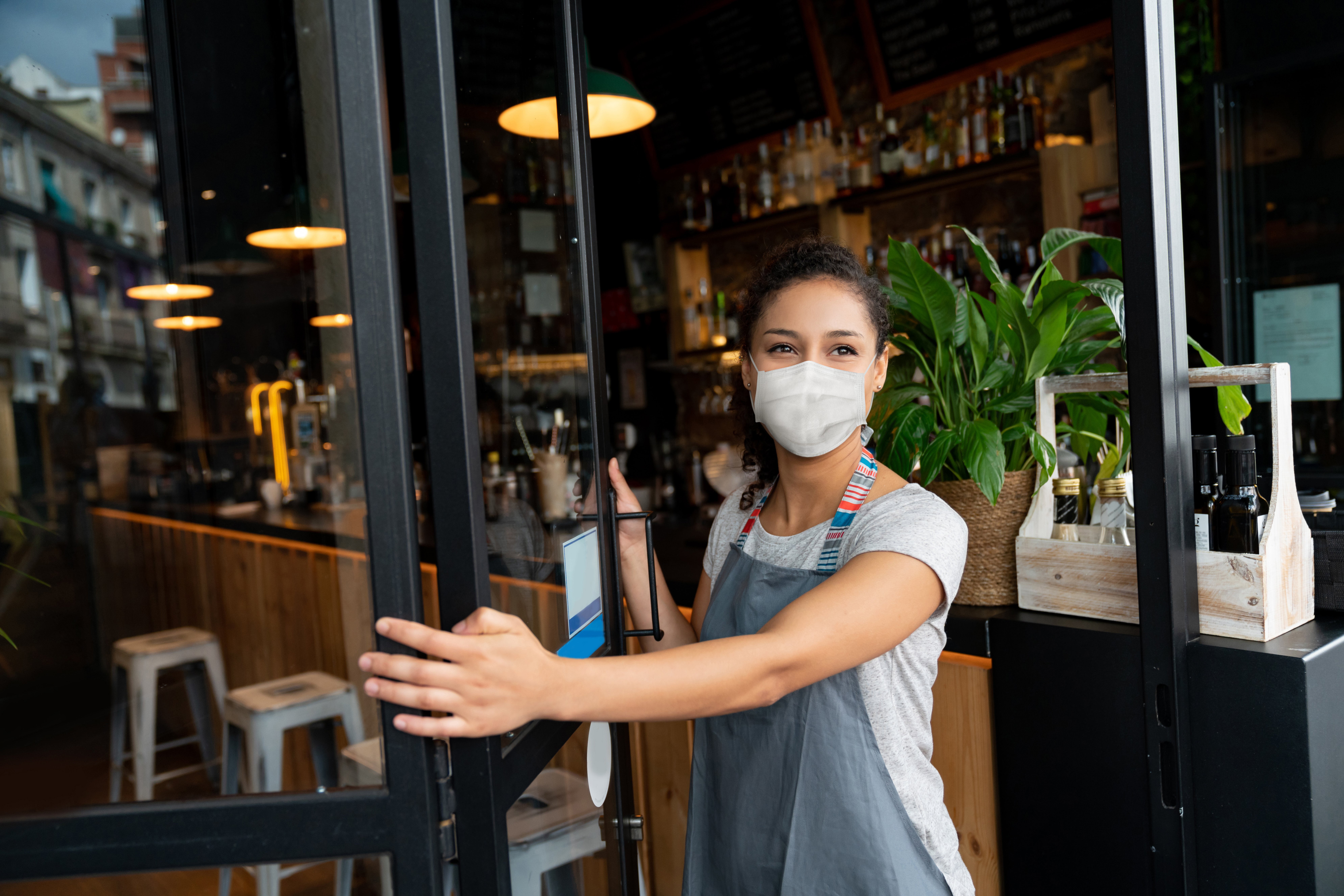 Woman in mask reopening small business